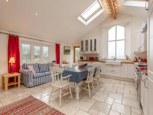 a kitchen and living room with a table and chairs at Hopewell Barn in Hewelsfield
