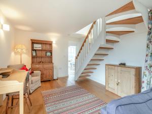 a living room with a staircase and a table at Hopewell Barn in Hewelsfield