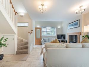 a living room with two couches and a fireplace at Windsmoor Cottage On Gower in Penrice