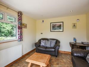 a living room with a couch and a chair at Beech - Glamping Pod - Uk49945 in Oswestry +9 photos