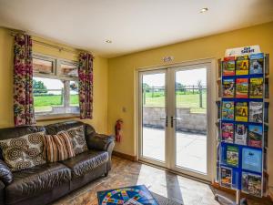 a living room with a couch and a sliding glass door at Beech - Glamping Pod - Uk49945 in Oswestry