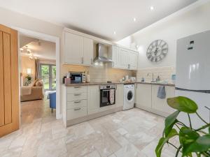 a kitchen with white cabinets and a dishwasher at Windsmoor Cottage On Gower in Penrice +21 photos