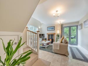 a living room with a staircase and a chair at Windsmoor Cottage On Gower in Penrice