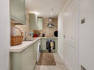 a kitchen with white cabinets and a sink at The Loft House in Canford Magna