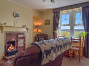 a living room with a couch and a fireplace at Rowan Cottage - Uk38991 in Dalcross
