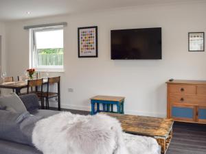 a living room with a couch and a tv at The Rest in St. Andrews