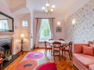 a living room with a table and chairs and a fireplace at Cliff House in Beesands