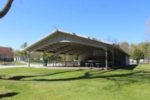 a pavilion in a park with a grass field at Tranquil Timbers Park Model 7 in Sturgeon Bay