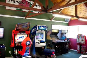 una habitación con 2 juegos de arcade y una consola de videojuegos en Tranquil Timbers Park Model 7, en Sturgeon Bay