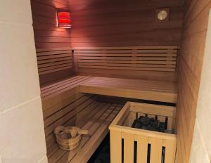 a sauna with a bench and a basket in a room at Haus Magnus SeaSide in Sylt