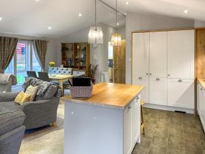 a kitchen and living room with a couch and a table at Chatsworth Lodge - Uk50983 in Felton +11 photos