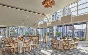 a dining room with tables and chairs and windows at Hyatt Regency La Jolla at Aventine in San Diego