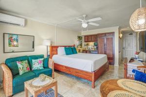 a bedroom with a bed and a couch in a room at Romantic Oceanfront Escape in Kapaa