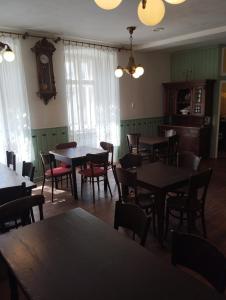a dining room with tables and chairs and a clock at Penzion Nad Kašnou in Kašperské Hory +17 photos