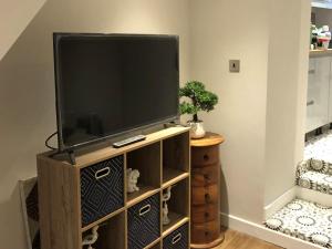 a flat screen tv sitting on a wooden entertainment center at Copper Crab Cottage in Amlwch