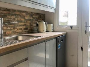 a kitchen with a sink and a counter top at Copper Crab Cottage in Amlwch