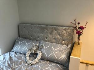 a bedroom with a bed with a heart shaped pillow at Copper Crab Cottage in Amlwch +6 photos