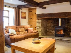 a living room with a couch and a fireplace at Colstey Farmhouse in Acton