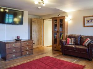 a living room with a couch and a dresser at Colstey Farmhouse in Acton