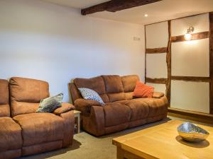 a living room with a couch and a table at Colstey Farmhouse in Acton +31 photos