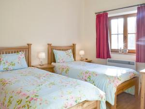 two beds sitting next to each other in a bedroom at Tan-Y-Derwwen in Mydroilin