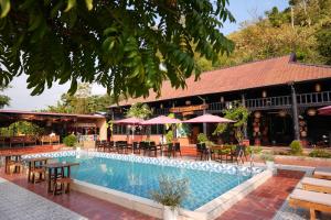 a resort with a swimming pool and tables and chairs at Cat Ba SOL Beach in Cat Ba