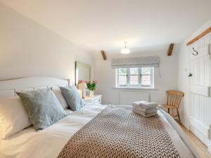 a white bedroom with a large bed and a window at Swallow Cottages, No 2 - Uk46810 in Thurgarton