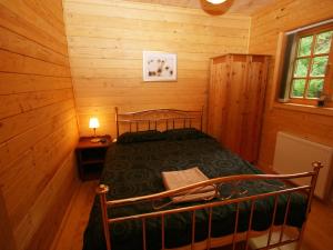 a bedroom with a bed in a wooden cabin at Auchenhill Lodge in Lochend