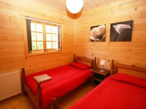 two beds in a room with wooden walls at Auchenhill Lodge in Lochend