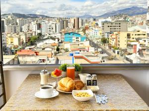 a breakfast table with a view of a city at Hotel Santamaria en quito in Quito