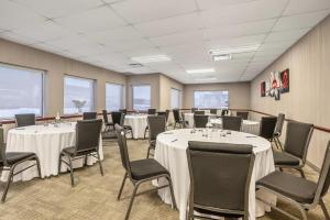a conference room with tables and chairs and windows at Comfort Inn Montreal - Laval - Highway 15 in Laval