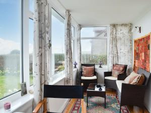 a living room with windows and chairs and a table at Craignair in Port William +22 photos