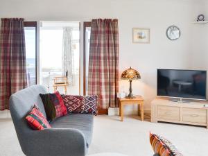 a living room with a couch and a tv at Craignair in Port William