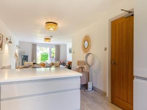 a kitchen with a white counter top and a living room at Pentreath 4 in St Ives