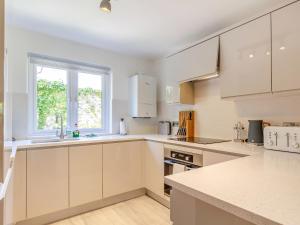 a kitchen with white cabinets and a window at Pentreath 4 in St Ives +17 photos