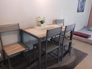 a dining room table and chairs with a vase of flowers on it at The Layover Condotel ,Palm Tree two Villas ,cluster 2 - unit 7q , New Port Boulevard , Newport City ,NAIA Terminal 3 , Pasay City , Philippines in Sampong