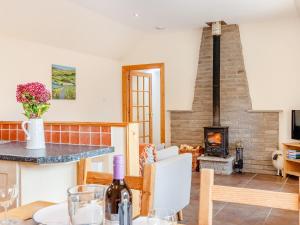 a kitchen and living room with a wood stove at The Steading Cottage in Glenfarg