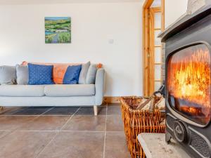 a living room with a couch and a fireplace at The Steading Cottage in Glenfarg
