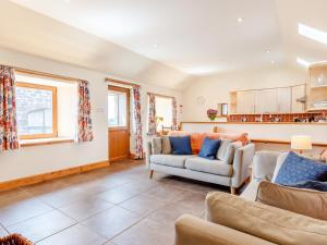 a living room with two couches and a kitchen at The Steading Cottage in Glenfarg
