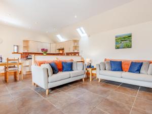 a living room with two couches and a kitchen at The Steading Cottage in Glenfarg +13 photos