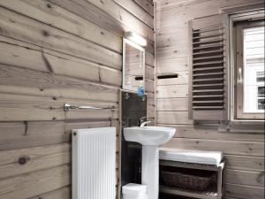 a bathroom with a white sink and wooden walls at Maple - Uk5501 in Killin +12 photos