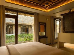 a bedroom with a bed and a large window at Anket De' River Mui Ne resort in Mui Ne