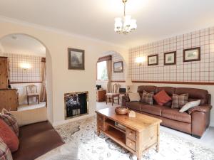 a living room with a couch and a table at Holly Cottage in Gorstan