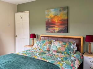 a bedroom with a bed and a painting on the wall at The Green in Lochranza