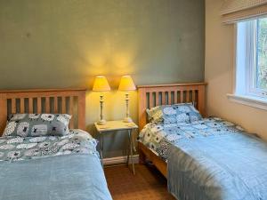 two beds sitting next to each other in a bedroom at The Green in Lochranza
