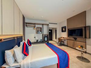 a bedroom with a large bed and a flat screen tv at Zip By Spree Hotels Chinchwad in Chinchwad