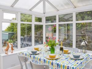 a conservatory dining room with a table and chairs at Seacliffe in Kildonan
