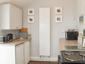 a kitchen with white cabinets and a stove at Seacliffe in Kildonan