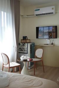 a room with a bed and a table and chairs at Mari Home in Bangsaen +10 photos