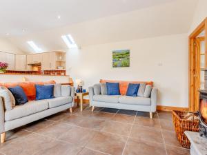 a living room with two couches and a fireplace at The Steading Cottage in Glenfarg